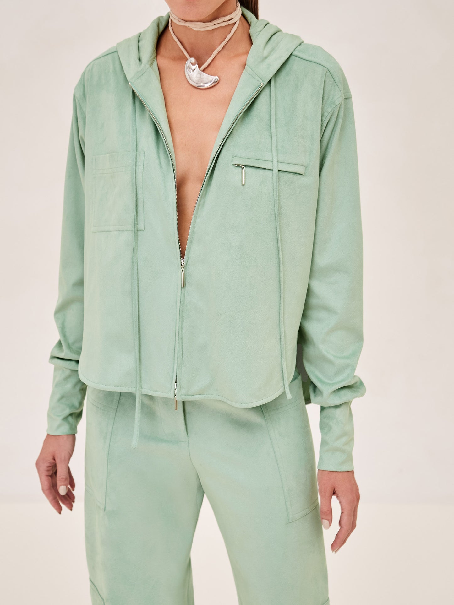 ALEXIS Suda top in sage with zipper and hood. 